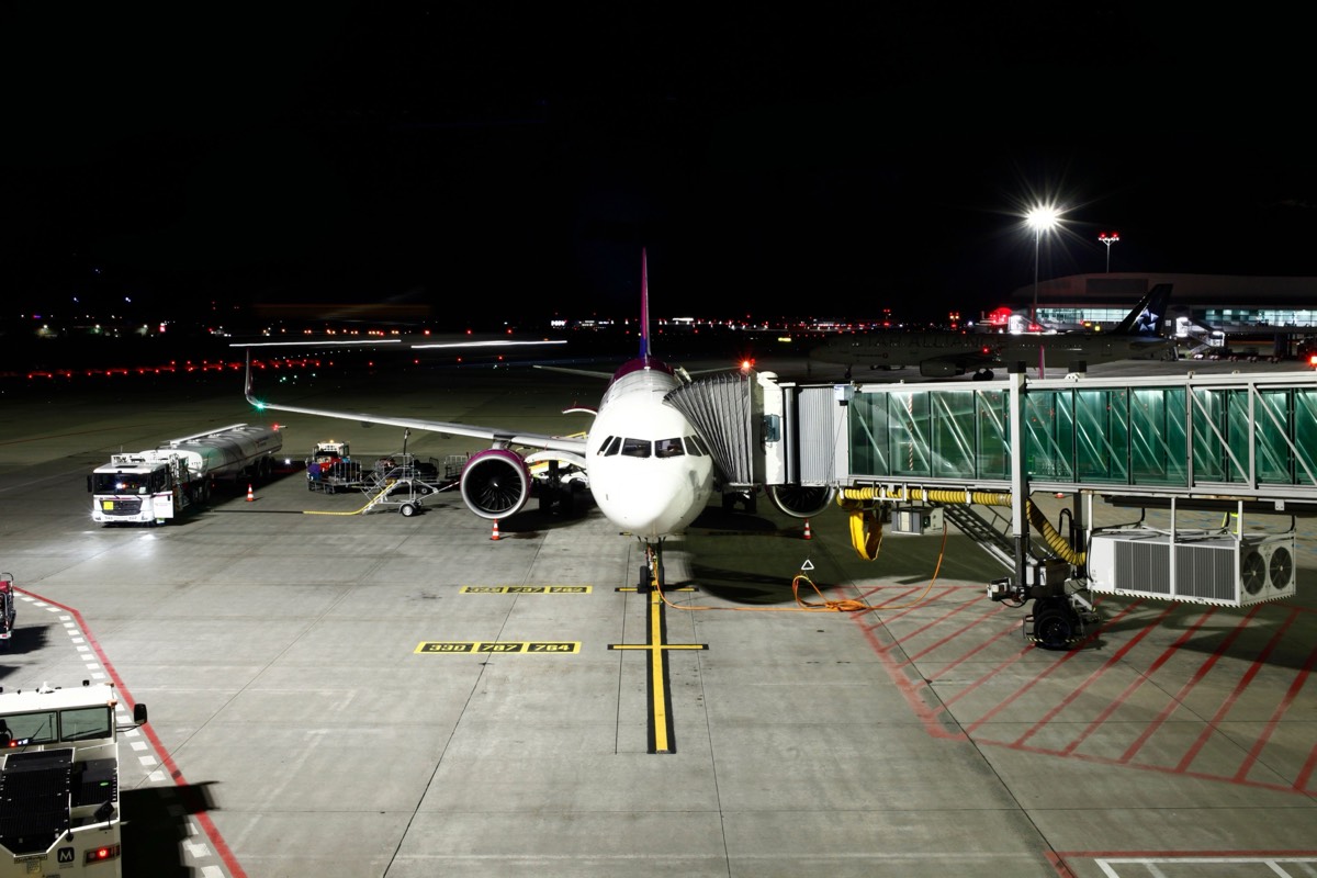 Passenger boarding bridge connected to an aircraft at a night gate
